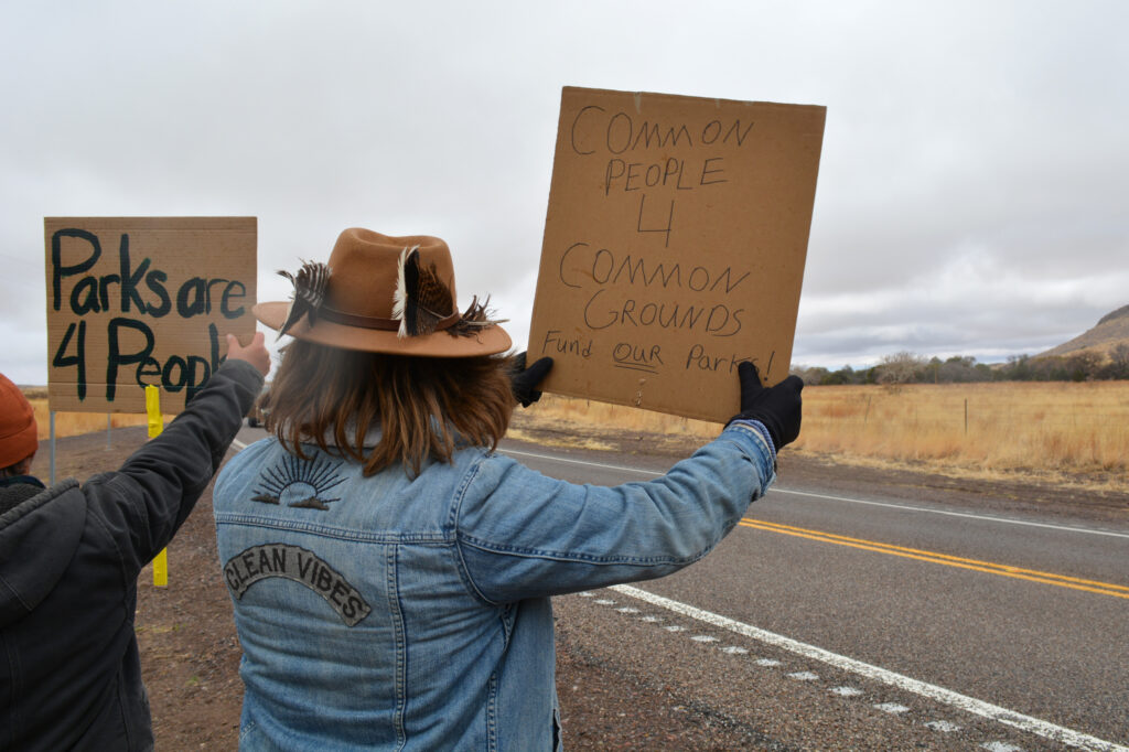 Owen Crowlie and Trevor Lauber display their protest signs to visitors of Chiricahua National Monument on March 15 in Cochise County, Ariz. Credit: Wyatt Myskow/Inside Climate News
