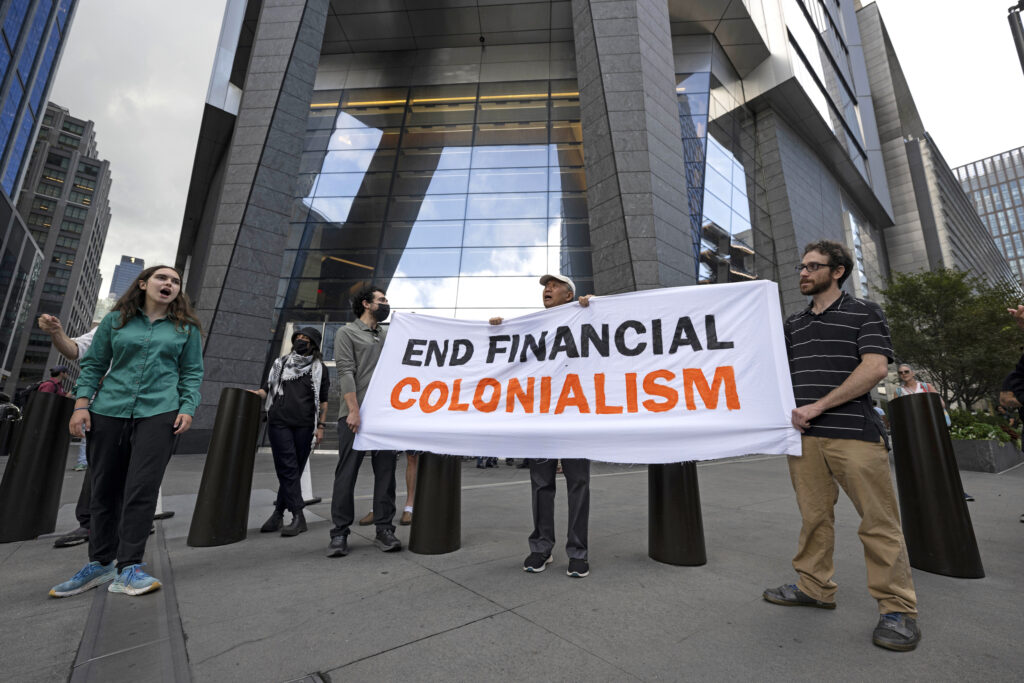 Reb Spring (left), the spokesperson for Debt for Climate, joins activists from Planet Over Profit to protest outside Wells Fargo’s corporate offices in New York City on July 23. Credit: Mostafa Bassim/Anadolu via Getty Images