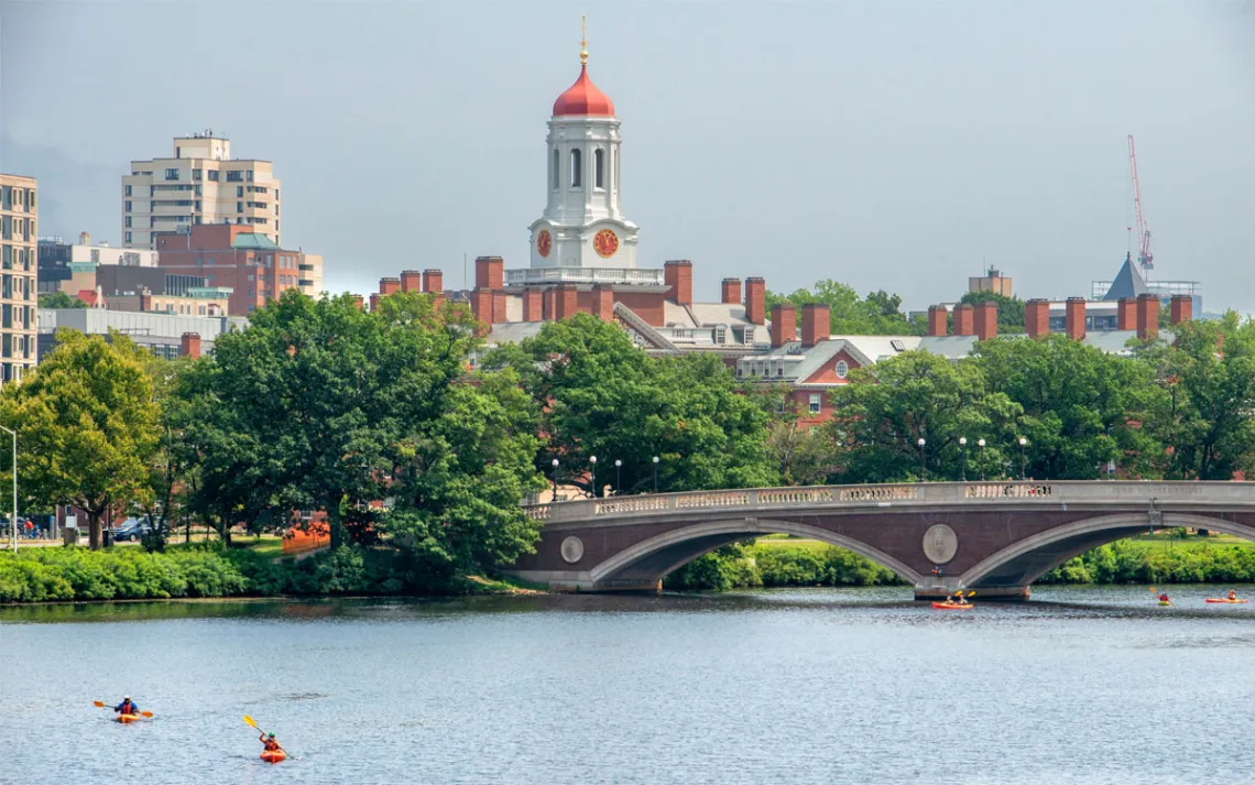 Caiaque sob a ponte John W. Weeks, no rio Charles, com o campus da Universidade de Harvard em Cambridge, Massachusetts, ao fundo.