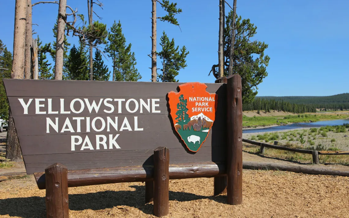 A placa do Parque Nacional de Yellowstone na entrada sul do lado de Grand Teton NP.