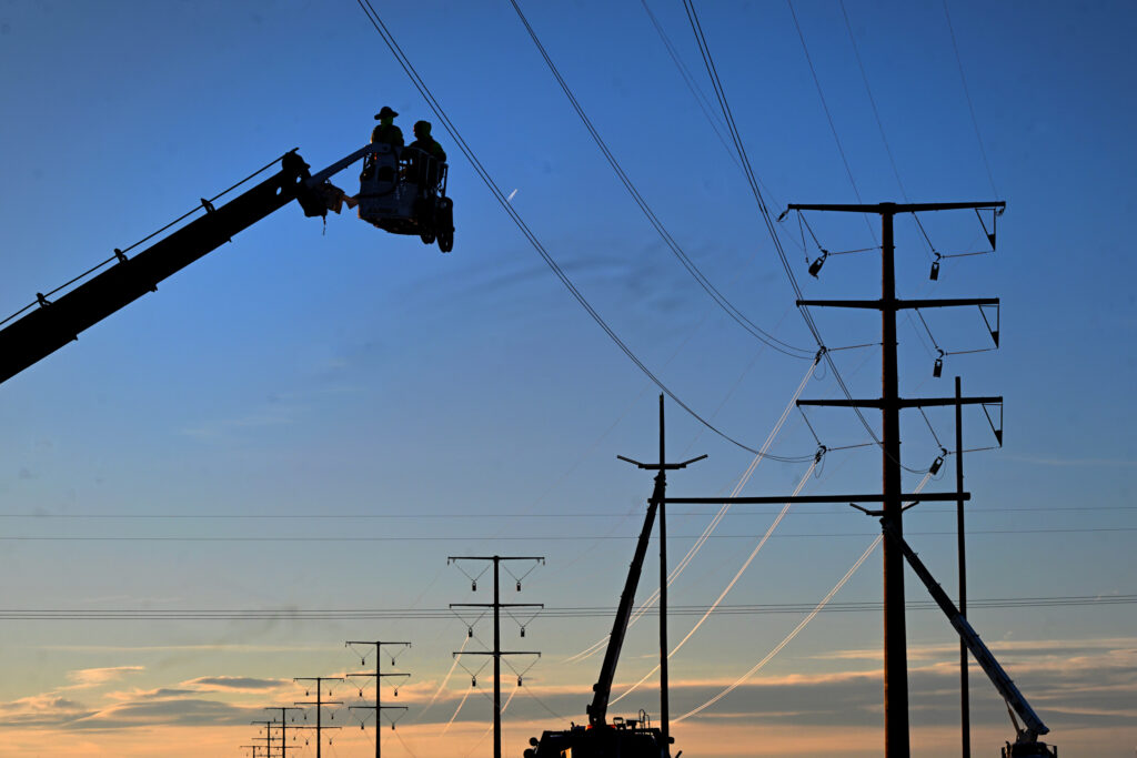 Working from the bucket of a boom truck linemen finish up work on large transmission structures that are part of an Xcel Energy project just south of Brush, Colo., on Jan. 8, 2024. Credit: Helen H. Richardson/MediaNews Group/The Denver Post via Getty Images