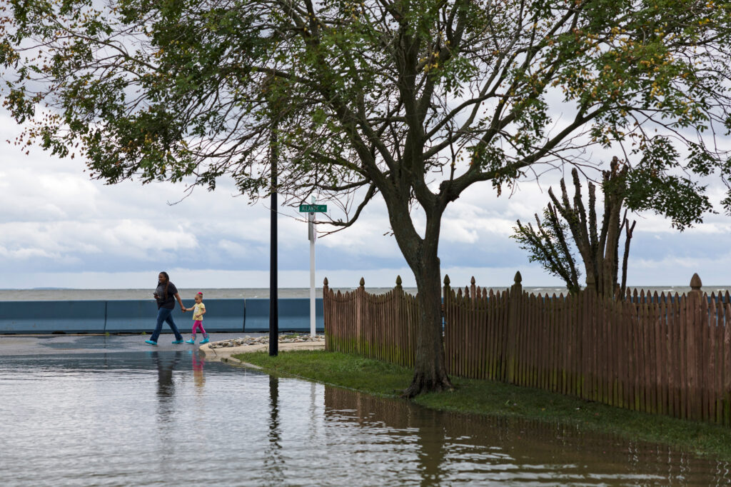 People walk along the shoreline of the Chesapeake Bay following heavy rain and flooding in North Beach, Md., on Aug. 9, 2024. Credit: Tom Brenner/The Washington Post via Getty Images