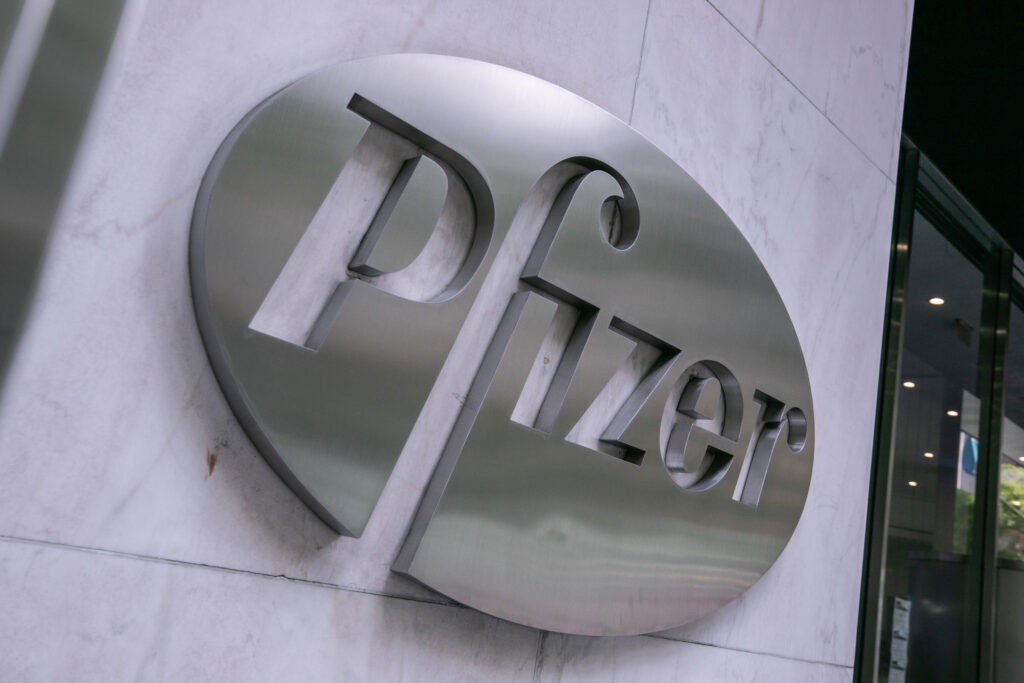 A sign for Pfizer is seen at the company’s headquarters in New York City. Credit: Jeenah Moon/Getty Images
