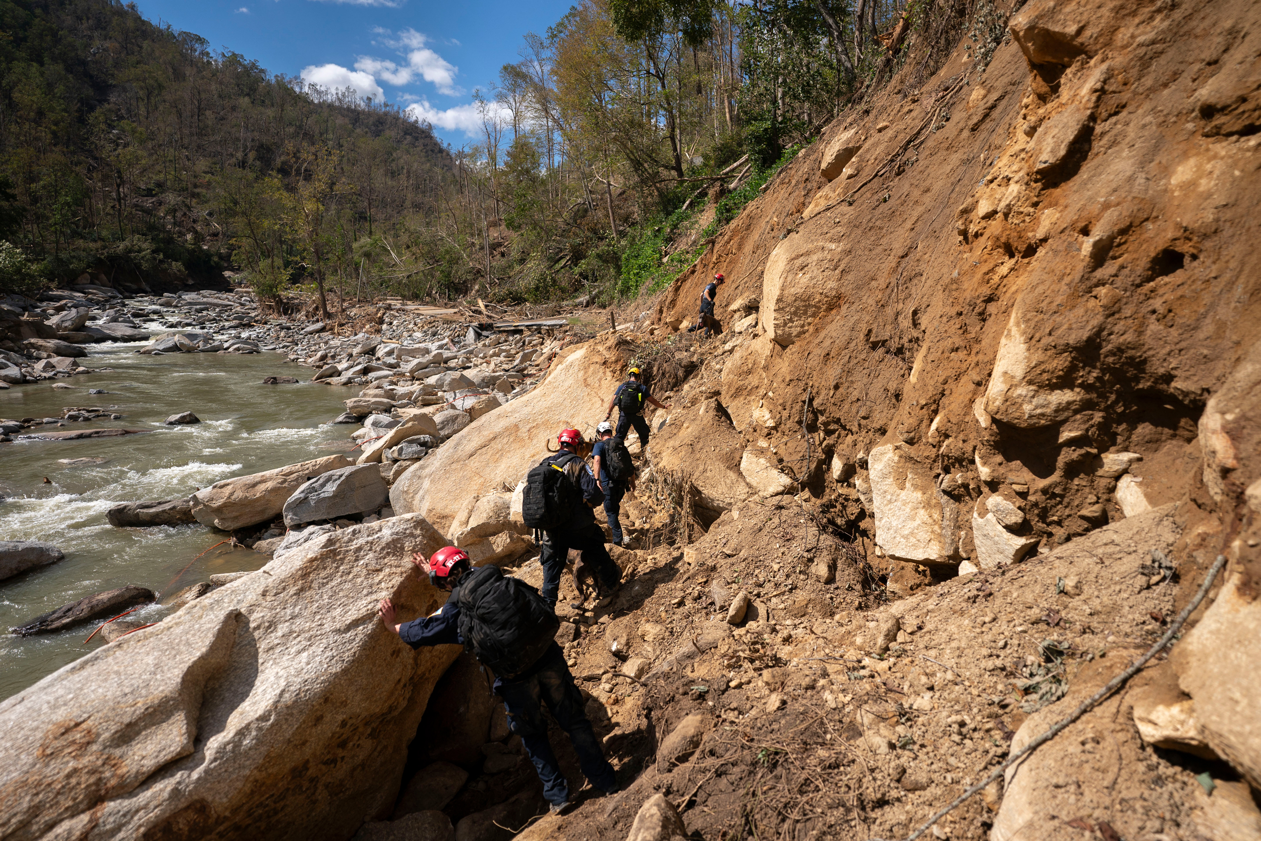 Membros de uma equipe de busca e resgate urbano da FEMA caminham ao longo do Broad River após o furacão Helene em 2 de outubro de 2024, perto de Chimney Rock, NC Crédito: Sean Rayford/Getty Images