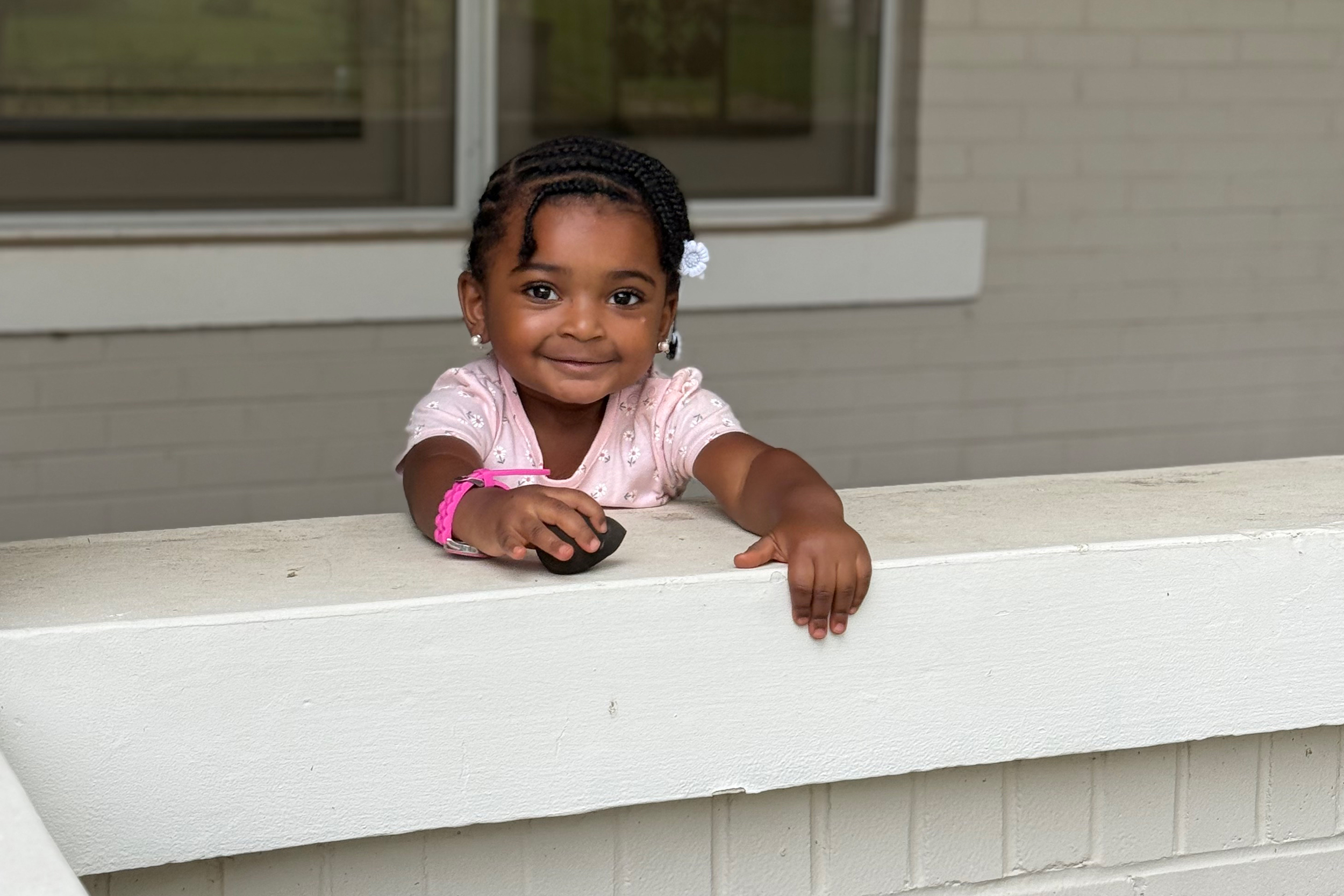 Amber DeLoney-Stewart’s 2-year-old daughter Valencia stands in front of their former home in East Trenton, N.J. Credit: Anna Mattson/Inside Climate News