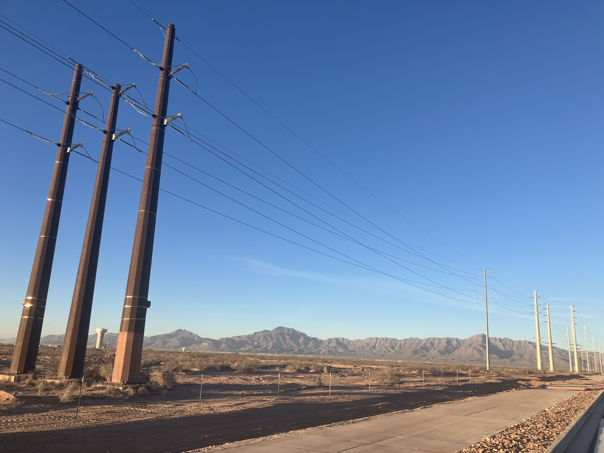 Transmission lines along Stan Roberts Sr. Avenue in Northeast El Paso, adjacent to the construction site of the Meta data center. The Franklin Mountains are visible in the background. Credit: Martha Pskowski/Inside Climate News