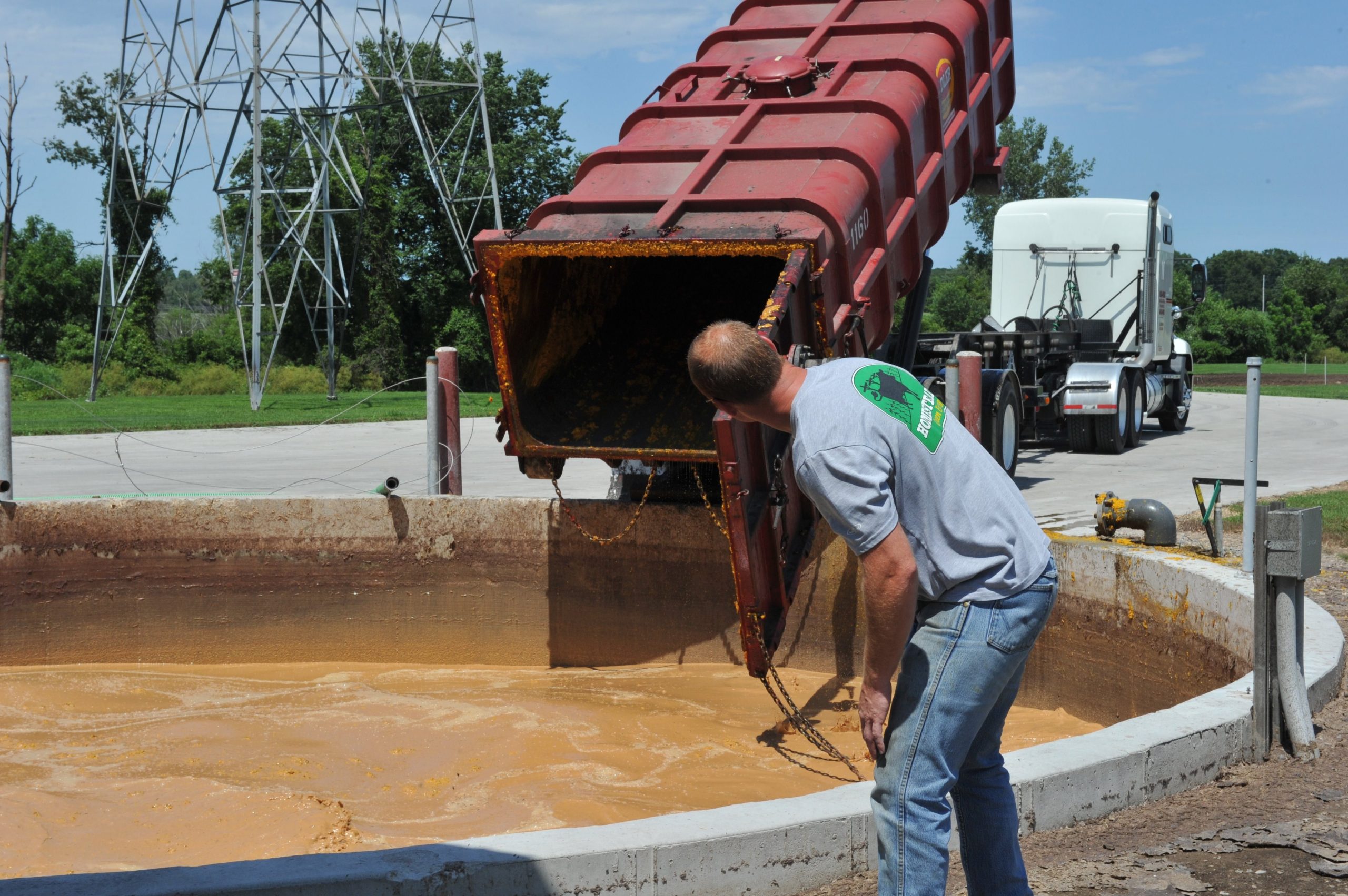 Farmer Ryan Rogers checks on a truck which has dumped food waste into a pit that feeds an anaerobic digester at Homestead Dairy in Plymouth, Indiana on July 13, 2015. The family-run farm invested in a biogas recovery system which transforms cow manure and other waste into enough electricity to power 1,000 homes. Credit: Mira Oberman /AFP via Getty Images