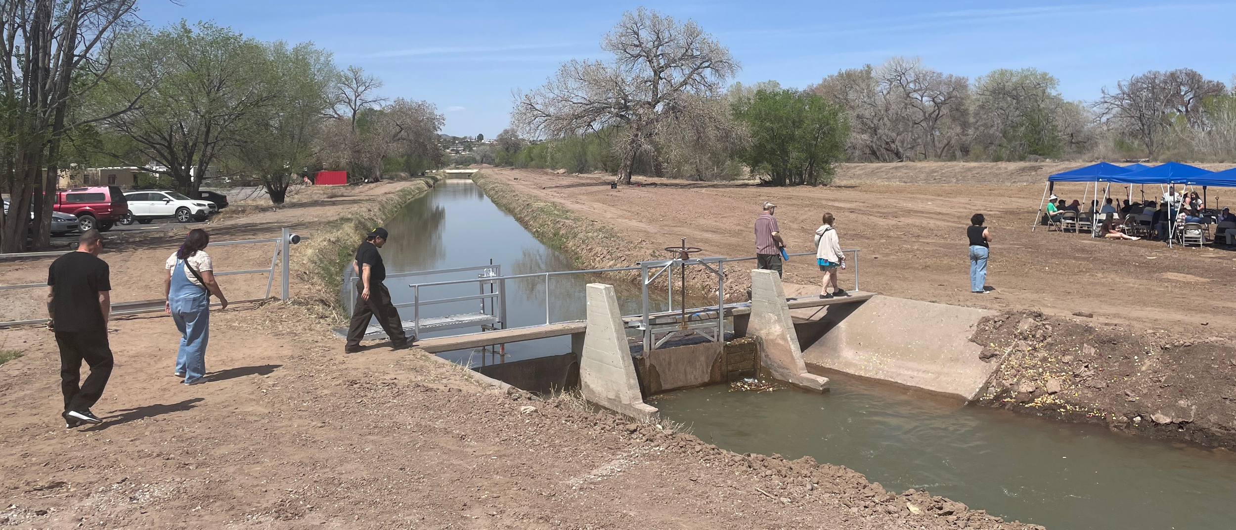 Pessoas atravessam uma ponte sobre o Atrisco Acequia Madre durante o evento Primera Agua em Albuquerque. Crédito: Tina Deines/Naturlink