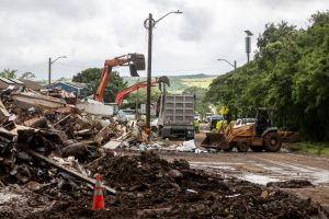 Excavators work to remove debris in Waialua, Hawaii, after a flood hit Oahu on March 23. Credit: Stephen Lam/San Francisco Chronicle via Getty Images