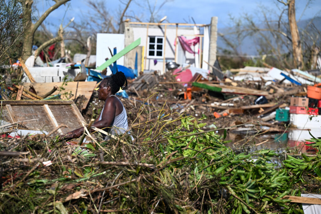 A woman clears debris near a damaged building on Oct. 29, 2025, following the passage of Hurricane Melissa in Black River, Jamaica. Credit: Ricardo Makyn/AFP via Getty Images