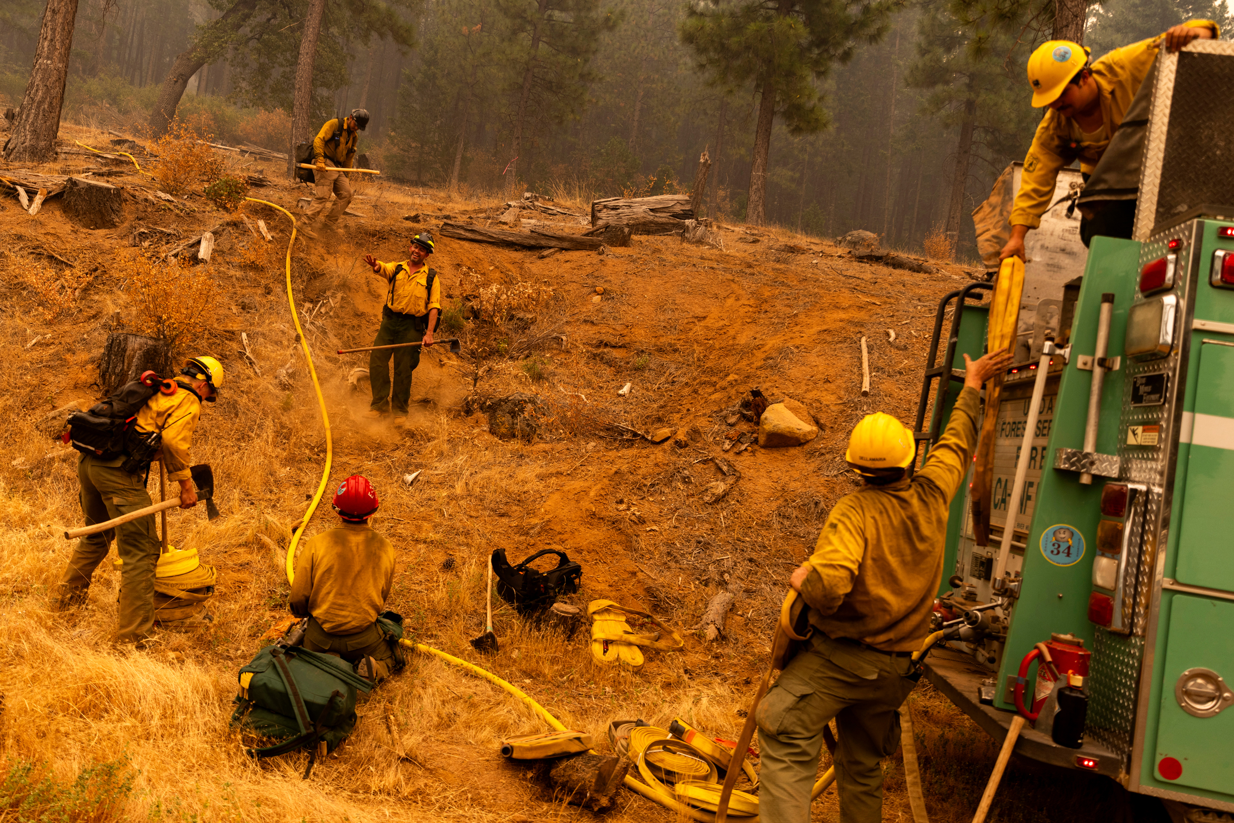 Os bombeiros do Serviço Florestal dos EUA preparam uma mangueira colocada em uma encosta durante o incêndio no parque no condado de Tehama, Califórnia, em 27 de julho de 2024. Crédito: Stephen Lam/San Francisco Chronicle via Getty Images