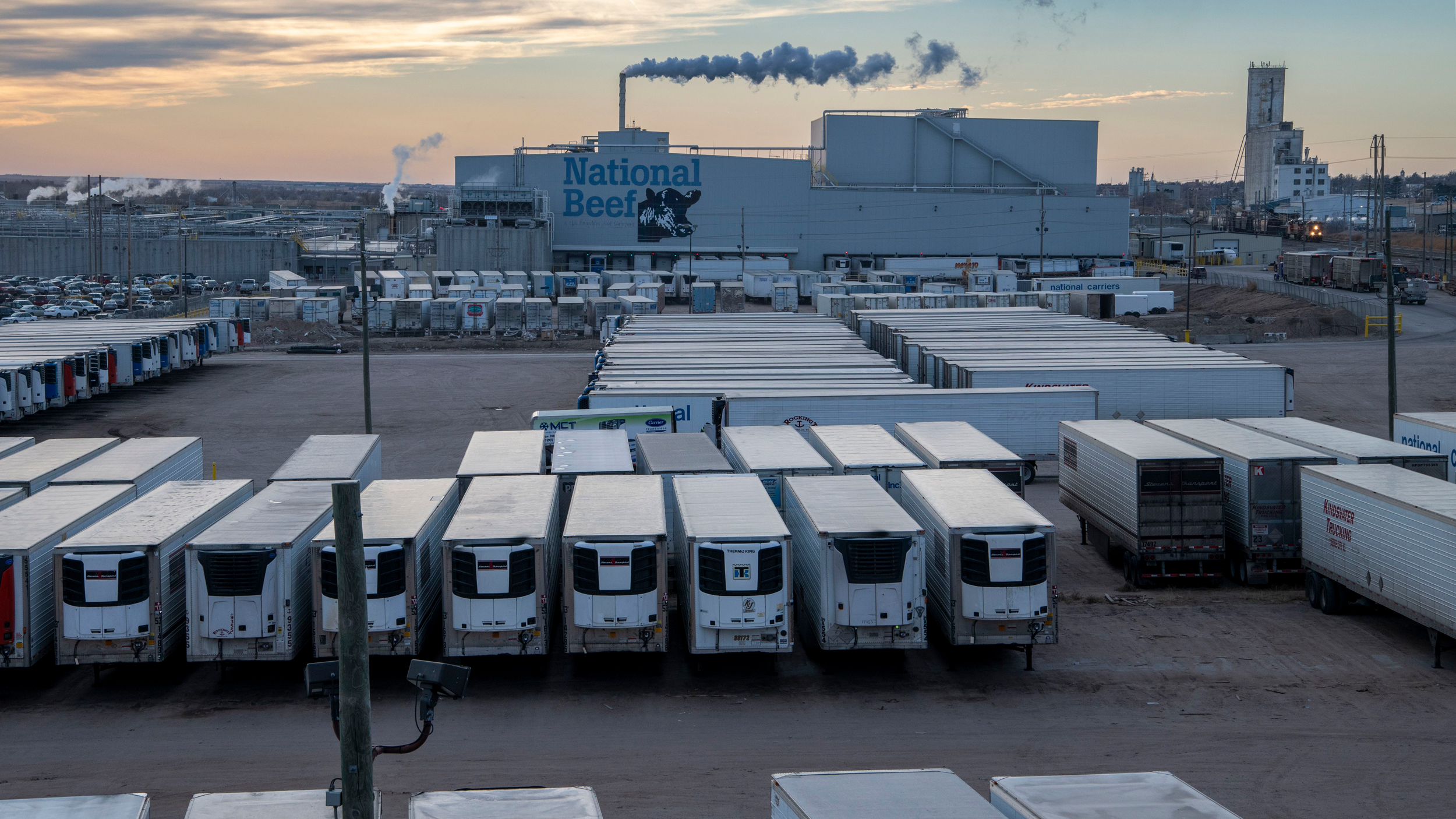 Reboques refrigerados ficam em frente a uma fábrica de processamento de carne bovina da National Beef em Dodge City, Kansas. Crédito: Michael Siluk/Universal Images Group via Getty Images