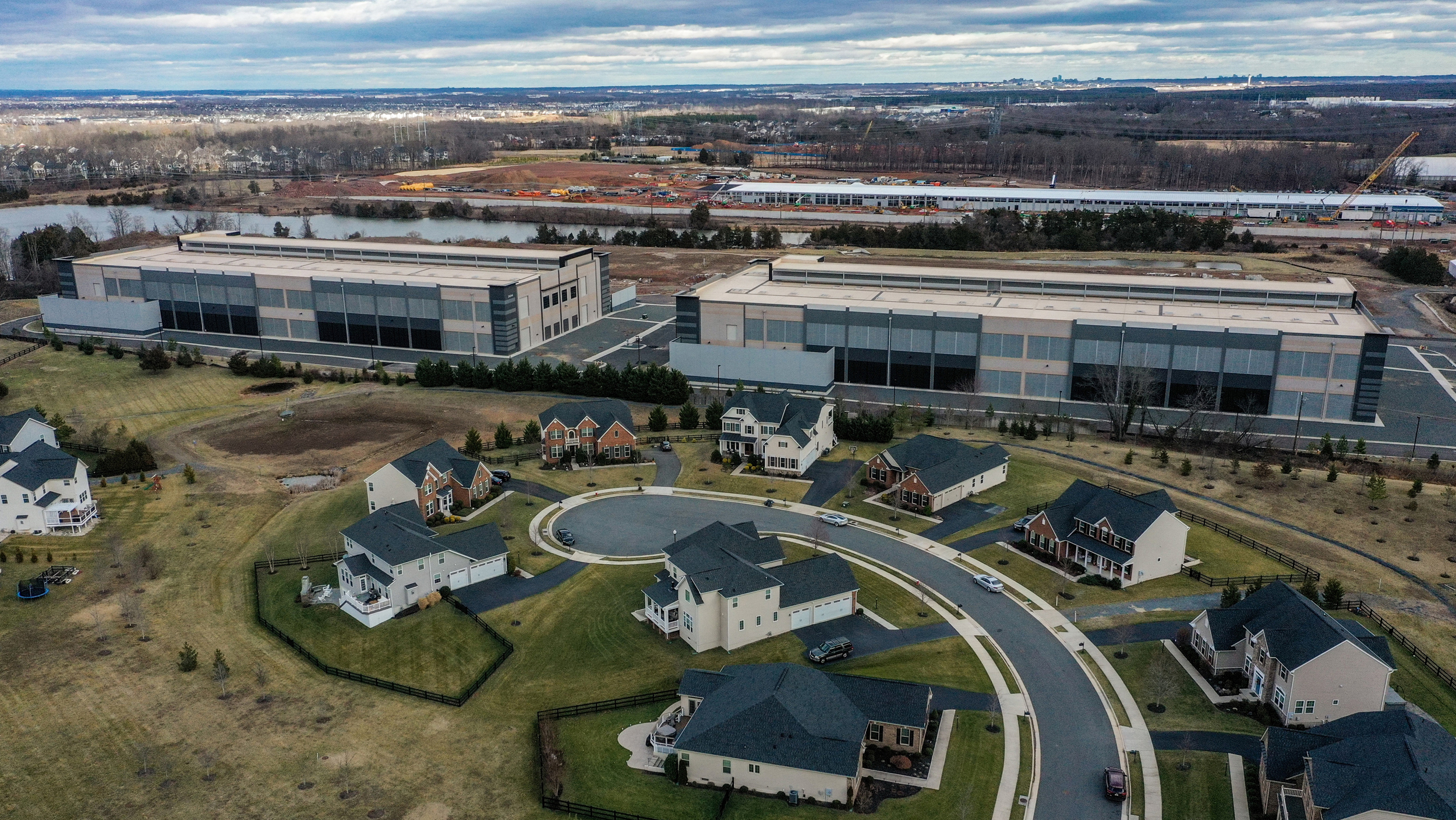 Os data centers da Amazon pairam sobre casas nos arredores de um bairro no condado de Loudoun, Virgínia. Crédito: Jahi Chikwendiu/The Washington Post via Getty Images