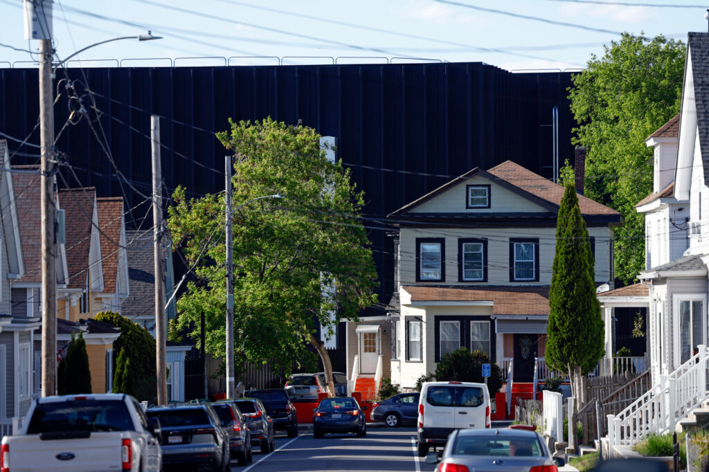 Lowell, MA - May 12: The view down a street in Lowell, Mass., where a data center looms behind residential housing on May 12. Credit: Danielle Parhizkaran/The Boston Globe via Getty Images