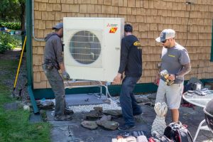 HVAC technicians install a heat pump system at a home in Charlotte, Vt., on July 21, 2025. Credit: Robert Nickelsberg/Getty Images