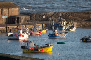 Fishing boats are moored in the harbor on March 2, 2026, in Lyme Regis, England.