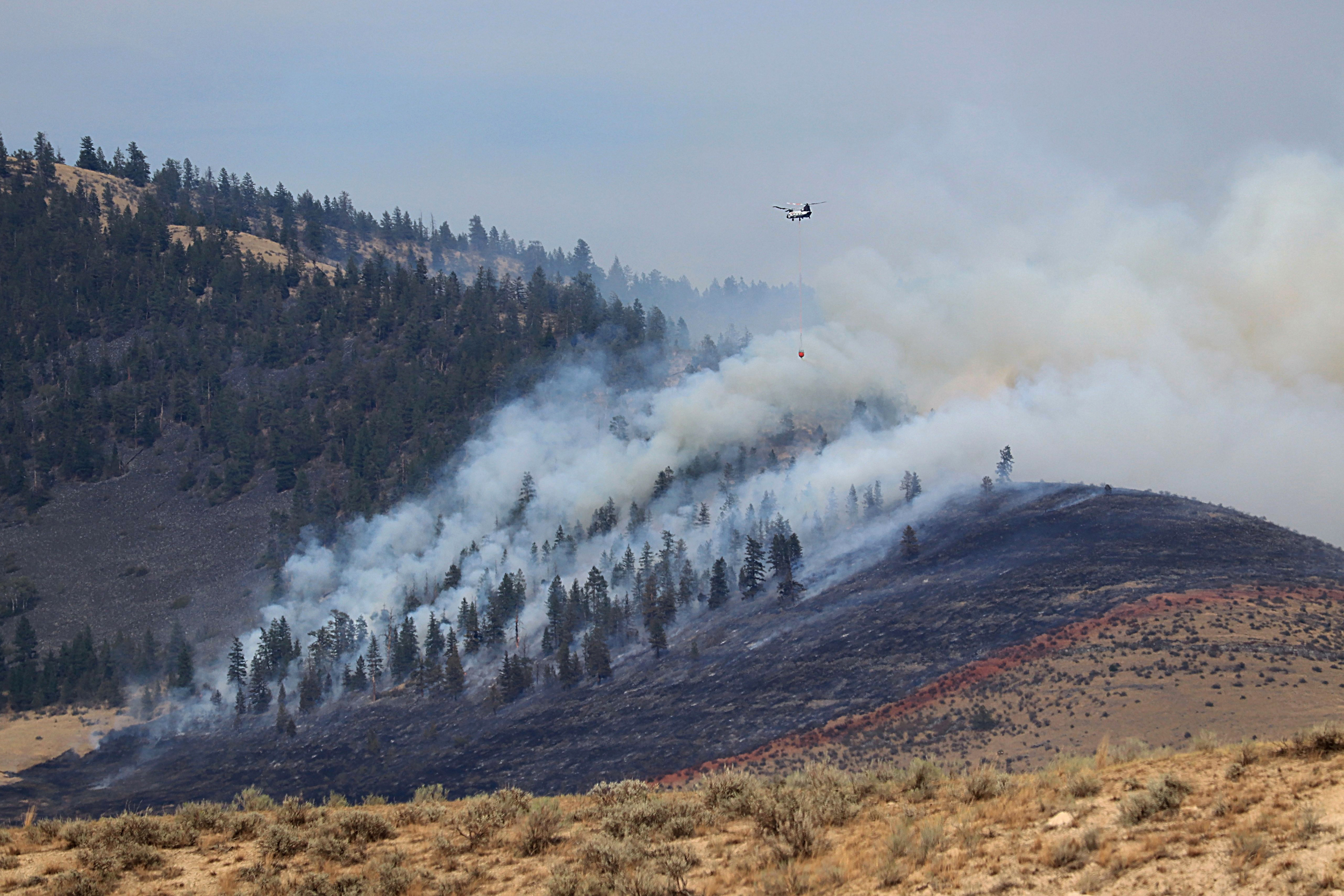Uma tripulação de helicóptero combate um incêndio florestal perto de Kalispell, Montana, em agosto de 2022. Crédito: Don e Melinda Crawford/Universal Images Group via Getty Images