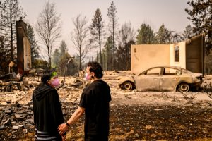 A couple visits their home destroyed by the Old Trails Fire in Spokane, Wash., on Tuesday. Credit: Josh Edelson/AFP via Getty Images