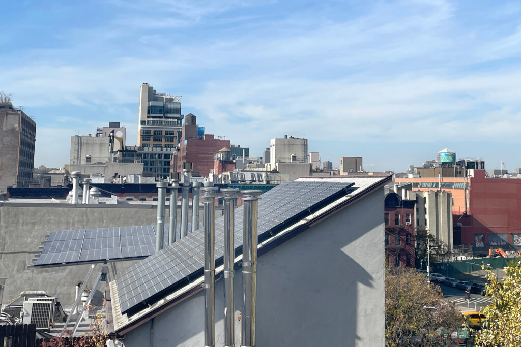 Painéis solares no telhado são instalados em um prédio de arenito em Manhattan. Crédito: Deb Cohn-Orbach/Grupo Universal Images via Getty Images