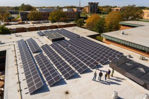 A worker explains the features of a commercial rooftop solar project that was installed by GAI Energy of Flora, Ind. Credit: GAI Energy