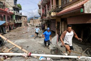 Locals walk through houses deluged in sludge after flash floods in Nepal’s Nuwakot district on Thursday. Credit: Prabin Ranabhat/AFP via Getty Images