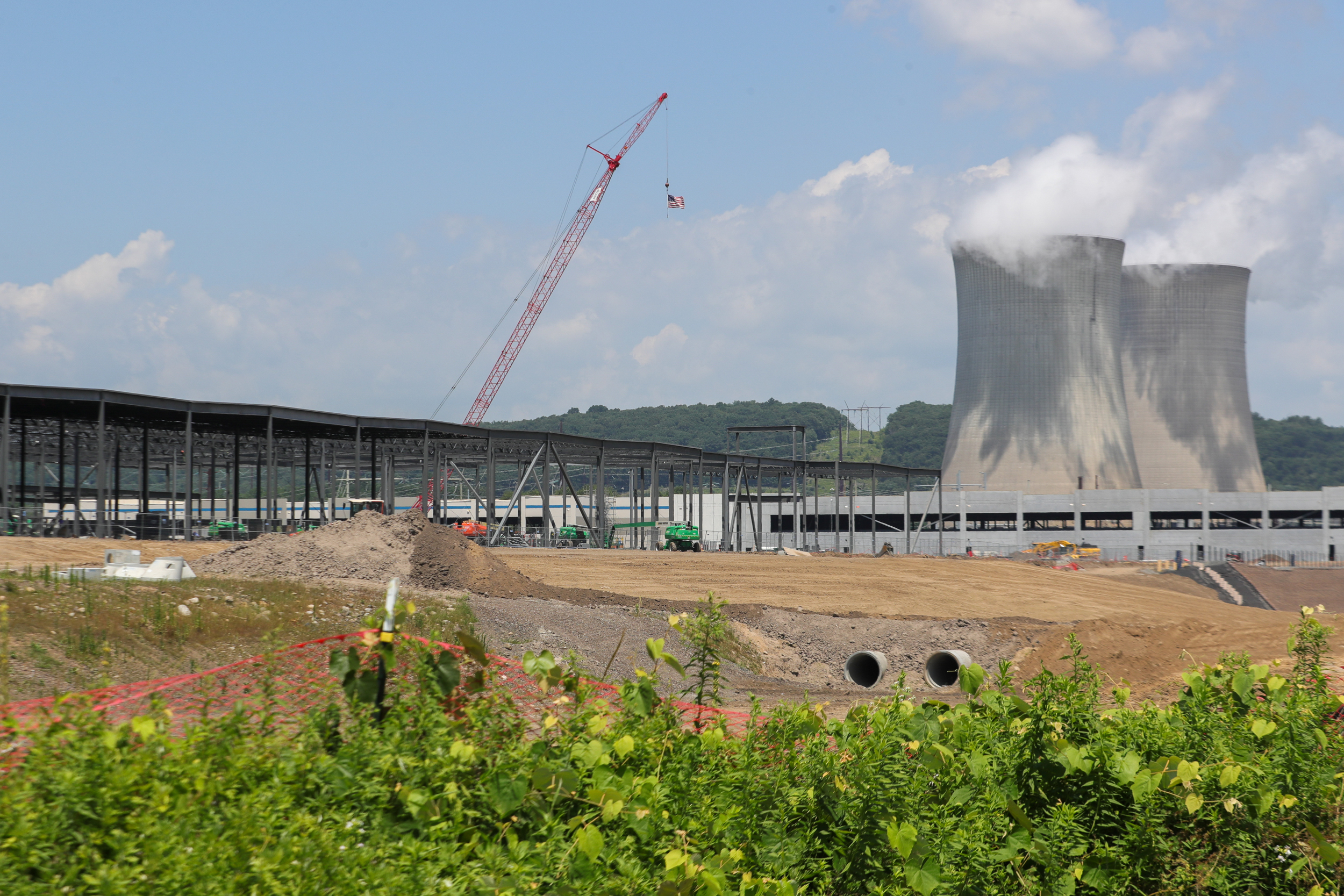 As torres de resfriamento da Estação Elétrica a Vapor Susquehanna da Talen Energy são vistas além do canteiro de obras de um data center da Amazon Web Services. Crédito: Paul Weaver/SOPA Images/LightRocket via Getty Images