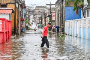 People walk through a flooded street in a neighborhood affected by Hurricane Melissa in Santiago de Cuba on Oct. 29, 2025. Credit: Yamil Lage/AFP via Getty Images