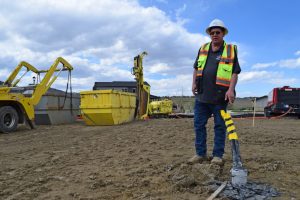 Shannon Dunphy, director of Mountain West construction at Dandelion Energy, oversees installation of polyurethane pipes for a geothermal system in Littleton, Colo. Credit: Phil McKenna/Inside Climate News