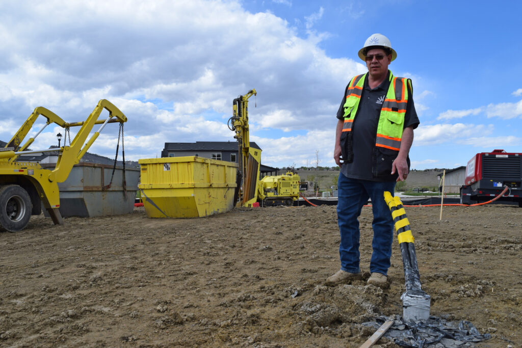 Shannon Dunphy, director of Mountain West construction at Dandelion Energy, oversees installation of polyurethane pipes for a geothermal system in Littleton, Colo. Credit: Phil McKenna/Inside Climate News
