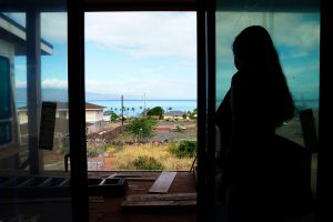 Wildfire survivor Krista Woodward opens the sliding glass door at her stalled home reconstruction on July 1 in Lahaina, Hawaiʻi. Credit: Kevin Fujii/Civil Beat