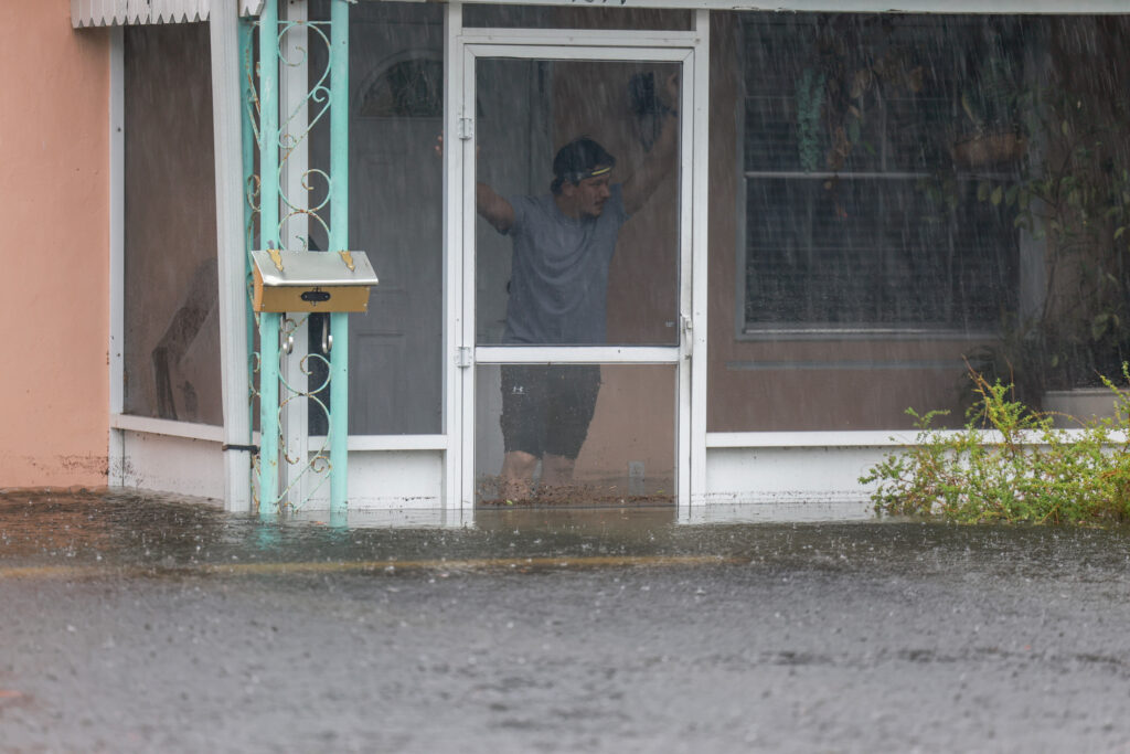 A man looks out at the floodwater surrounding his home on June 12, 2024, in Hollywood, Fla. Credit: Joe Raedle/Getty Images
