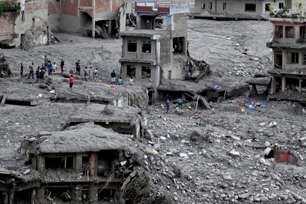 People search through debris in the aftermath of flash flooding at Trishuli Center in Nepal’s Nuwakot district on Sept. 1. Credit: Arun Sankar/AFP via Getty Images