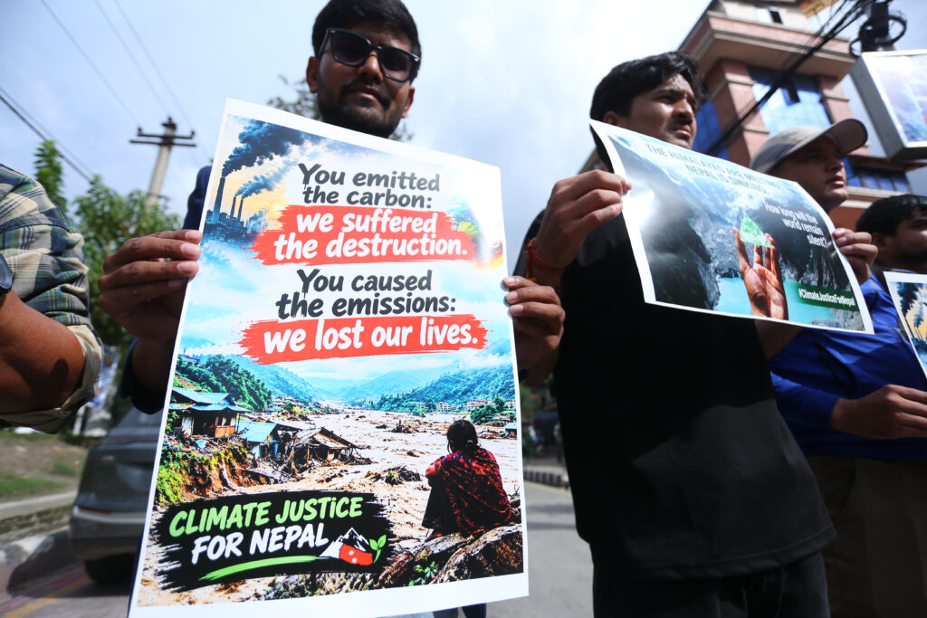 Several people are visible in the photo holding signs. One reads: