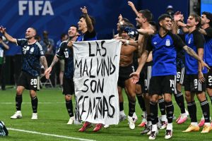 Argentina’s national team players hold a banner reading “The Malvinas are Argentine” after winning a World Cup semifinal match against England in Atlanta on July 15. Credit: Paul Ellis/AFP via Getty Images