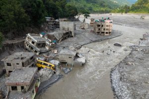 Muddy water surges past houses and through the Trishuli river in the aftermath of flash floods in Nepal’s Nuwakot district on Aug. 29. Credit: Prabin Ranabhat/AFP via Getty Images