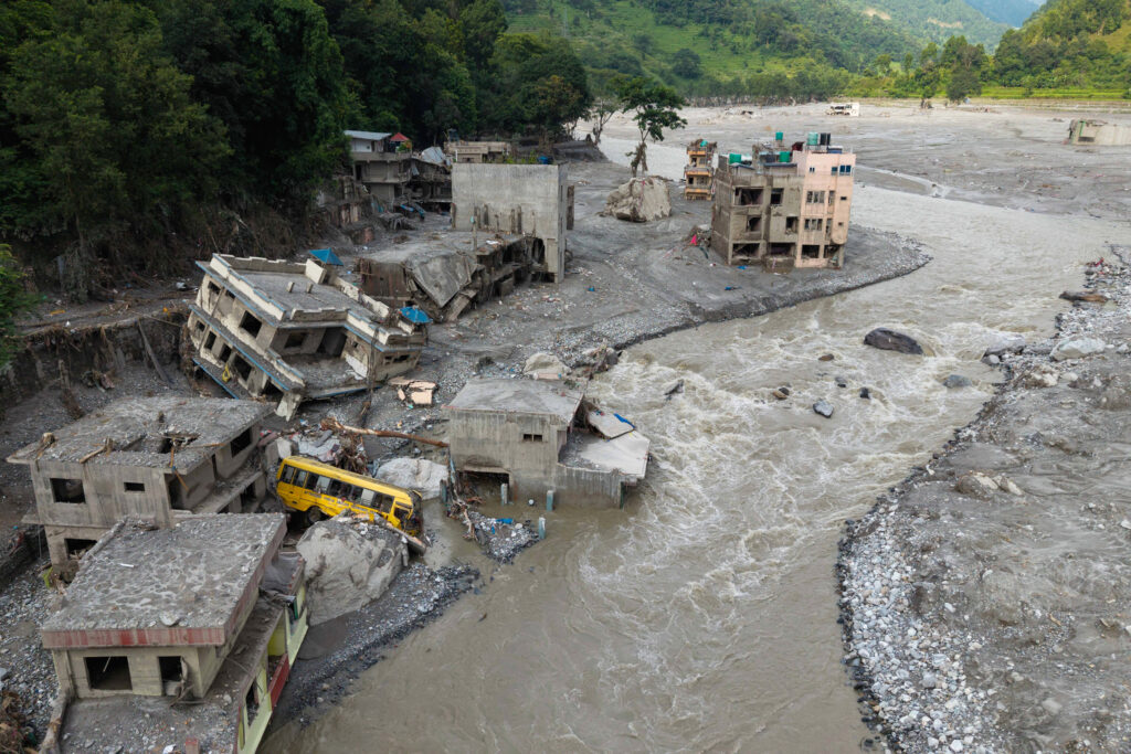Muddy water surges past houses and through the Trishuli river in the aftermath of flash floods in Nepal’s Nuwakot district on Aug. 29. Credit: Prabin Ranabhat/AFP via Getty Images