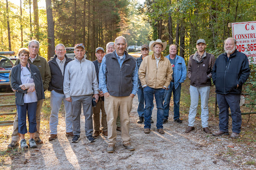 Fenn Church, center, is flanked by supporters at the gate of his property in Shelby County, Alabama. Photo credit: Lee Hedgepeth/ Inside Climate News