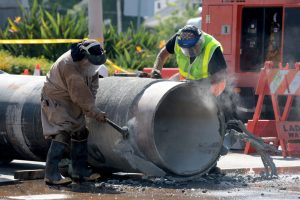 Crews prepare a replacement pipe as they repair a water main in West Hollywood, Calif., on July 17. Credit: Myung J. Chun/Los Angeles Times via Getty Images
