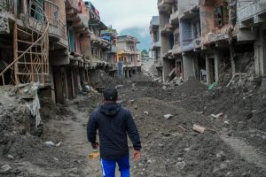A man walks past debris from houses damaged by devastating floods in Devighat, in Nepal