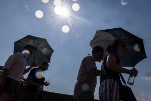 People shelter from the sun under umbrellas in Warsaw’s Old Town as Poland experienced record heat on June 28. Credit: Wojtek Radwanski/AFP via Getty Images